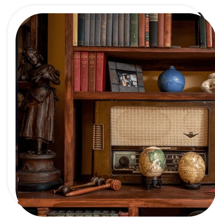 A bookshelf with books and an old globe on it.
